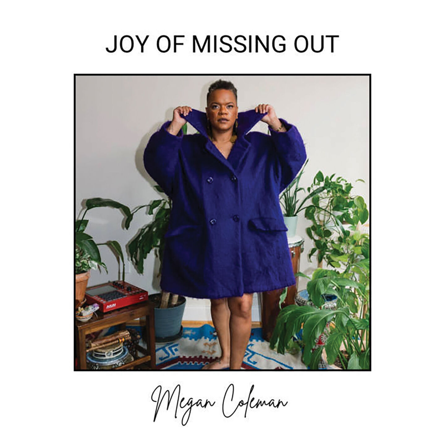 album art Megan Coleman Joy of Missing Out artist in a dark blue coat stares into the camera against a white background